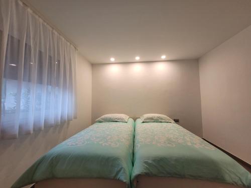 a bedroom with two beds in front of a window at Apartment river Nadiža Podbela in Podbela