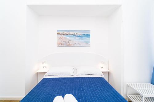 a bedroom with a blue bed with a painting on the wall at FRENNESIA Amalfi Coast in Atrani