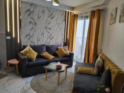 a living room with a blue couch and a marble wall at Porto Said in Port Said