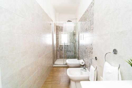 a white bathroom with two toilets and a shower at FRENNESIA Amalfi Coast in Atrani
