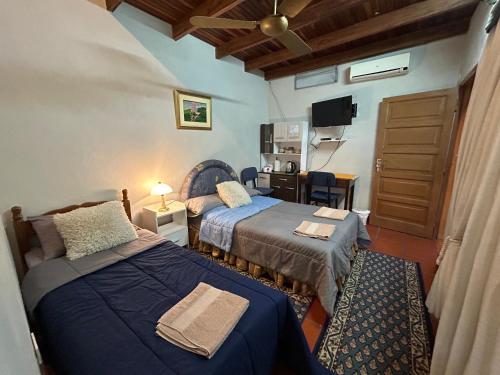a hotel room with two beds and a television at Habitación en suite, Excelente Ubicación in Asuncion