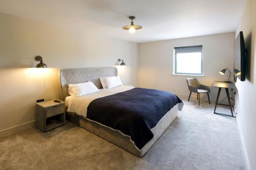 a bedroom with a large bed and a desk at Archstone House in Blackburn