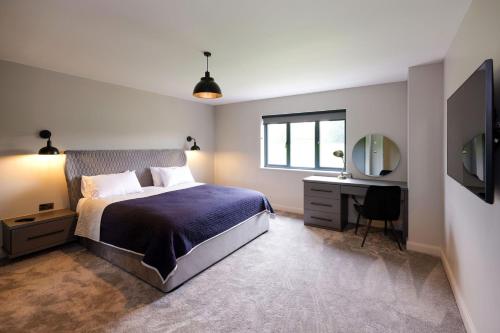 a bedroom with a bed and a desk and a mirror at Mylstone House in Blackburn