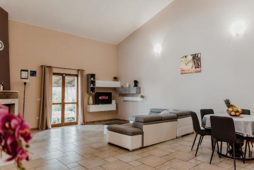 een woonkamer met een tafel en een bank bij Trullo Della Murgia - Villa in Castel del Monte