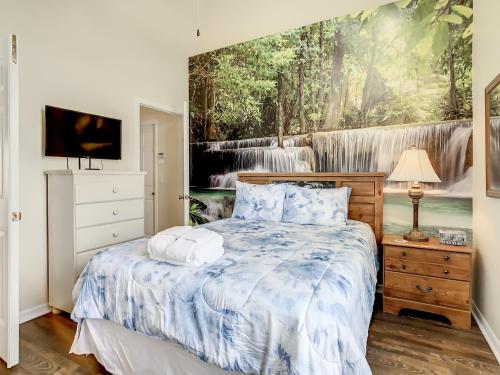 a bedroom with a bed with a painting on the wall at Family retreat w pool near Disney & parks in Orlando