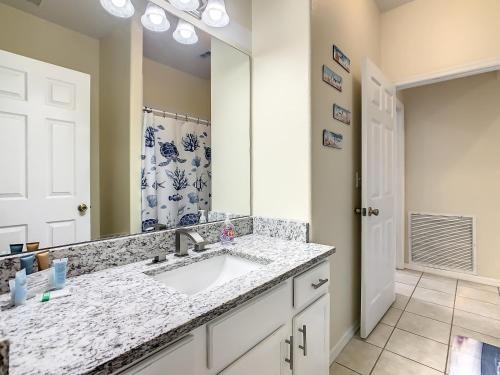 a bathroom with a sink and a mirror at Family retreat w pool near Disney & parks in Orlando