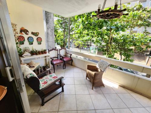 a room with several chairs and a window at Pitangueiras 3 quartos aconchegante , esquina com a praia e shopping in Guarujá