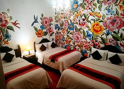 Habitación con 2 camas y papel pintado con motivos florales. en Casona Dorada Hotel Cusco, en Cusco