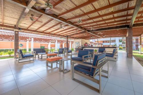 a patio with blue chairs and tables in a building at Best Western Jaco Beach All Inclusive Resort in Jacó