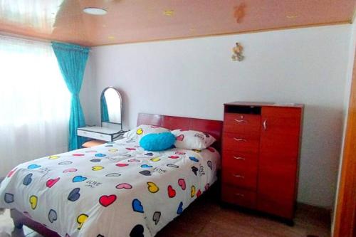 Schlafzimmer mit einem Bett und einer roten Kommode in der Unterkunft Apartamento Familiar, cerca al Aeropuerto in Bogotá