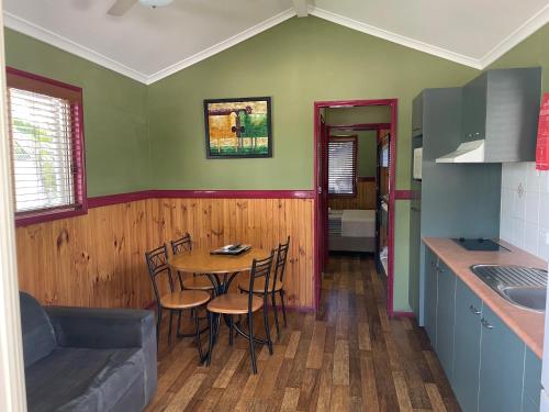a kitchen with a table and chairs in a room at Aussie Outback Oasis Holiday Park in Charters Towers