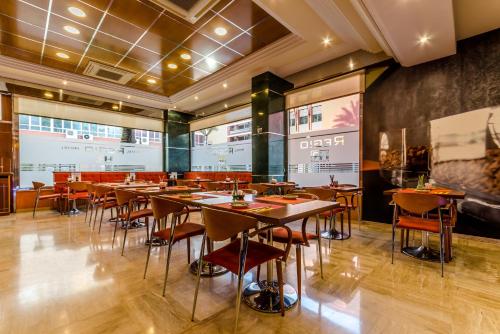 a restaurant with tables and chairs in a room at Hotel Regio Cádiz in Cádiz