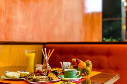 a table with breakfast foods and a glass of orange juice at Hotel Regio Cádiz in Cádiz
