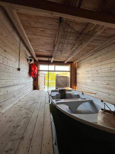 a boat sitting in a room with a wooden floor at Laivu Māja in Alūksne