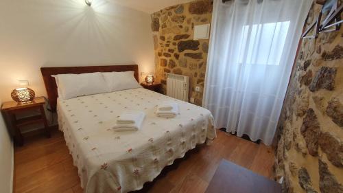 a bedroom with a bed with two towels on it at Casa Caminho da Ponte in Monção