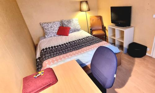 een kleine kamer met een bed, een tafel en een televisie bij Superbe chambre à clés Paris in Sartrouville