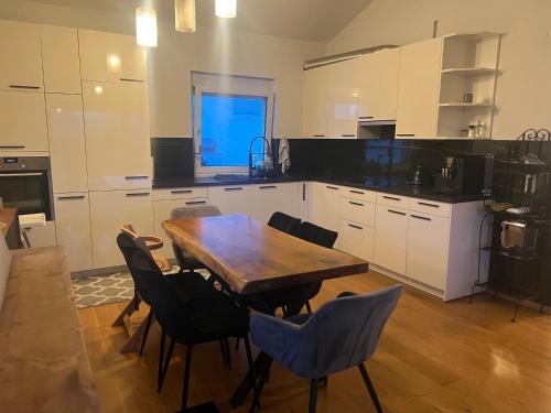 a kitchen with a wooden table and chairs at Era Home Deluxe in Murg