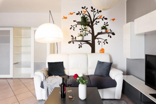 a living room with a white couch and a tree wall decal at [Strategico Rho Fiera-Milano] Vanzago Home Deluxe in Vanzago