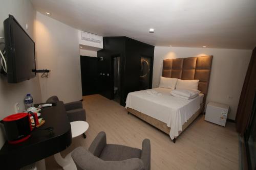 een hotelkamer met een bed en een televisie bij SAFRAN GERMİA PALaS in Bostanbükü