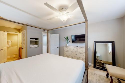 a bedroom with a white bed and a mirror at Seascape Golf Villas 40D in Destin