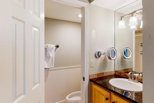 a bathroom with a sink and a toilet and a mirror at Seascape Golf Villas 40D in Destin