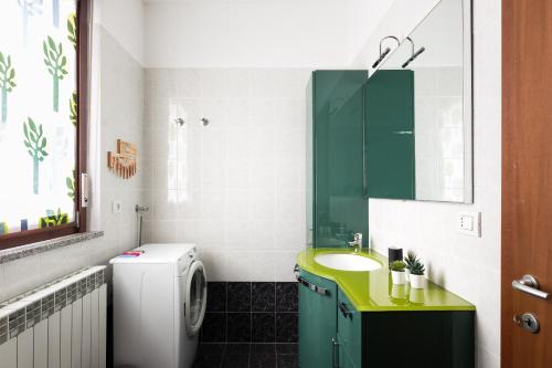 uma casa de banho com um lavatório e uma máquina de lavar roupa em [Strategico Rho Fiera-Milano] Vanzago Home Deluxe em Vanzago