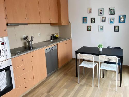 - une cuisine avec une table, deux chaises et une cuisinière dans l'établissement Watermark Beach Apartments, à Espinho