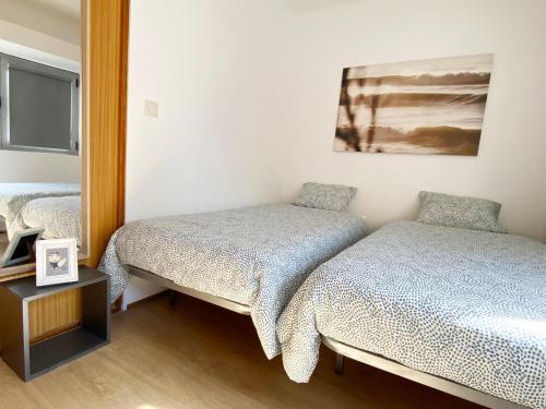 - une chambre avec 2 lits et un miroir dans l'établissement Watermark Beach Apartments, à Espinho