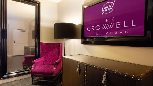 a room with a tv and a red chair at The Cromwell, A Caesars Destination in Las Vegas