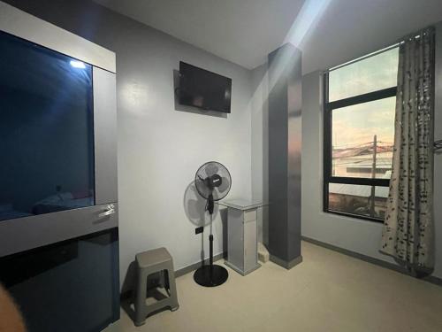 a living room with a fan and a window at Adrian´s Hotel in Pucallpa