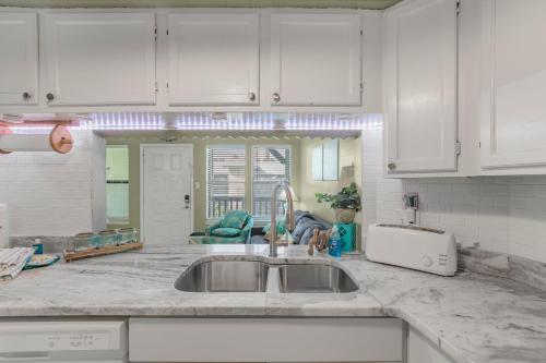 cocina con fregadero y armarios blancos en Sea Breeze 316 by Vacation Homes Collection en Gulf Shores