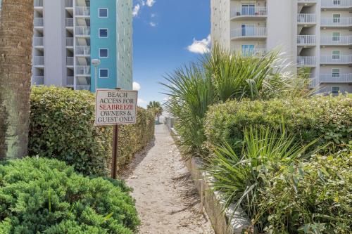 a sign in front of a building with plants at Sea Breeze 316 by Vacation Homes Collection in Gulf Shores