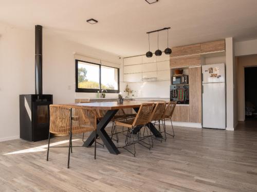 a kitchen with a table and chairs in a room at Casa en la naturaleza con vistas a las Sierras in La Cumbre