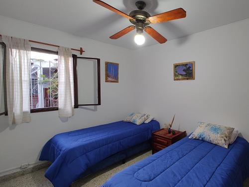 a bedroom with two beds and a ceiling fan at Casa Kuyay in San Salvador de Jujuy