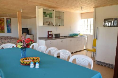 a kitchen with a blue table and white chairs at VILLA ERIKA comoda casa bellisima vista in Paipa