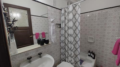 a bathroom with a sink and a toilet and a mirror at Casa Kuyay in San Salvador de Jujuy