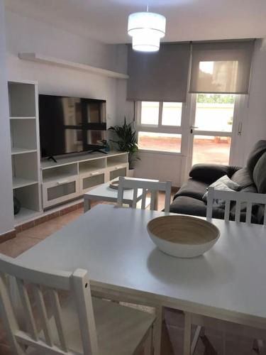 eine Küche und ein Wohnzimmer mit einem weißen Tisch und Stühlen in der Unterkunft Piso vacacional en Bueu. in Bueu