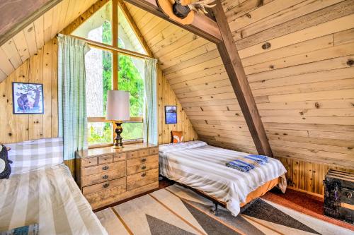 a bedroom in a log cabin with a bed and a window at Trail's End Cabin in Lilliwaup