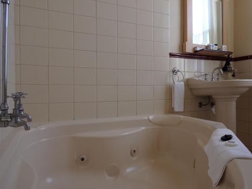a bathroom with a bath tub and a sink at The Glenferrie Hotel Hawthorn in Melbourne