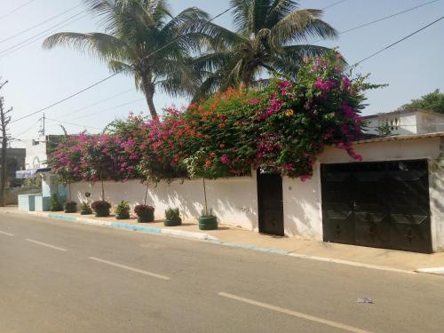 a building with flowers on the side of a street at keur alain in Sali Nianiaral