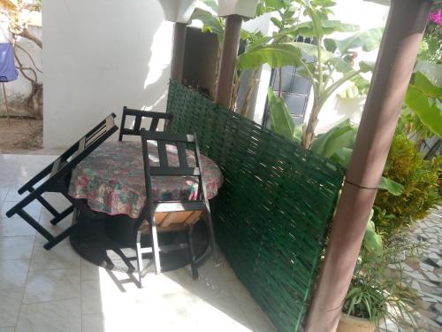 a table and chairs on a balcony with a green fence at keur alain in Sali Nianiaral