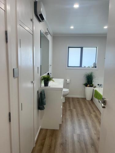 a bathroom with a sink and a toilet and a window at B&B at whitbourne in Otorohanga