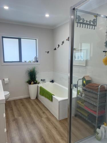 a white bathroom with a tub and a shower at Beauty at whitbourne in Otorohanga