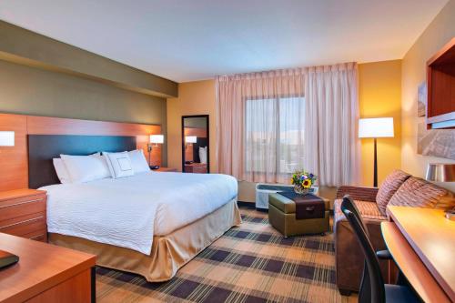 a hotel room with a bed and a living room at TownePlace Suites by Marriott Billings in Billings