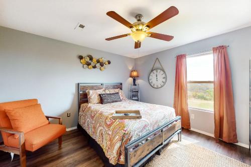 a bedroom with a bed and a ceiling fan and a chair at Making Branson Memories - Unit 1 in Branson