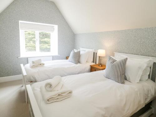 two twin beds in a room with a window at Gwern Borter Manor in Conwy