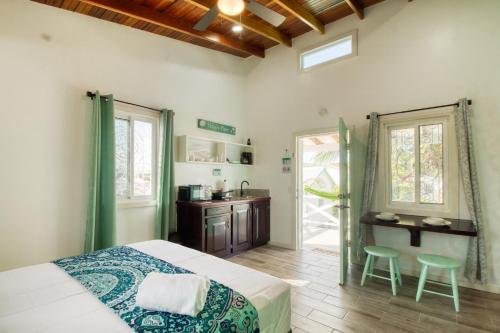 a bedroom with a bed and two stools in it at DV 4 at DV Cabanas Gold Standard Certified in Caye Caulker