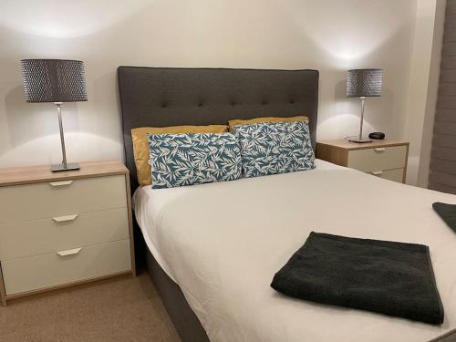 a bedroom with a large bed with two night stands and two lamps at Spacious 2 Bedroom Modern Flat in London