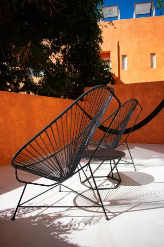 a metal bench sitting on a sidewalk next to a wall at Sayulinda Hotel in Sayulita