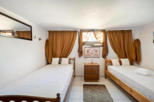 1 dormitorio con 2 camas y espejo en Boem Villa in Nafpliο, en Nea Kios